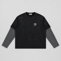 A black long-sleeve t-shirt with a distressed, faded look, featuring a small white and red graphic on the left chest with a crown and the letters 'ST'. The sleeves are solid dark gray, and there are subtle speckled distress marks across the body.
