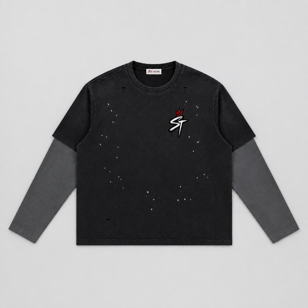A black long-sleeve t-shirt with a distressed, faded look, featuring a small white and red graphic on the left chest with a crown and the letters 'ST'. The sleeves are solid dark gray, and there are subtle speckled distress marks across the body.