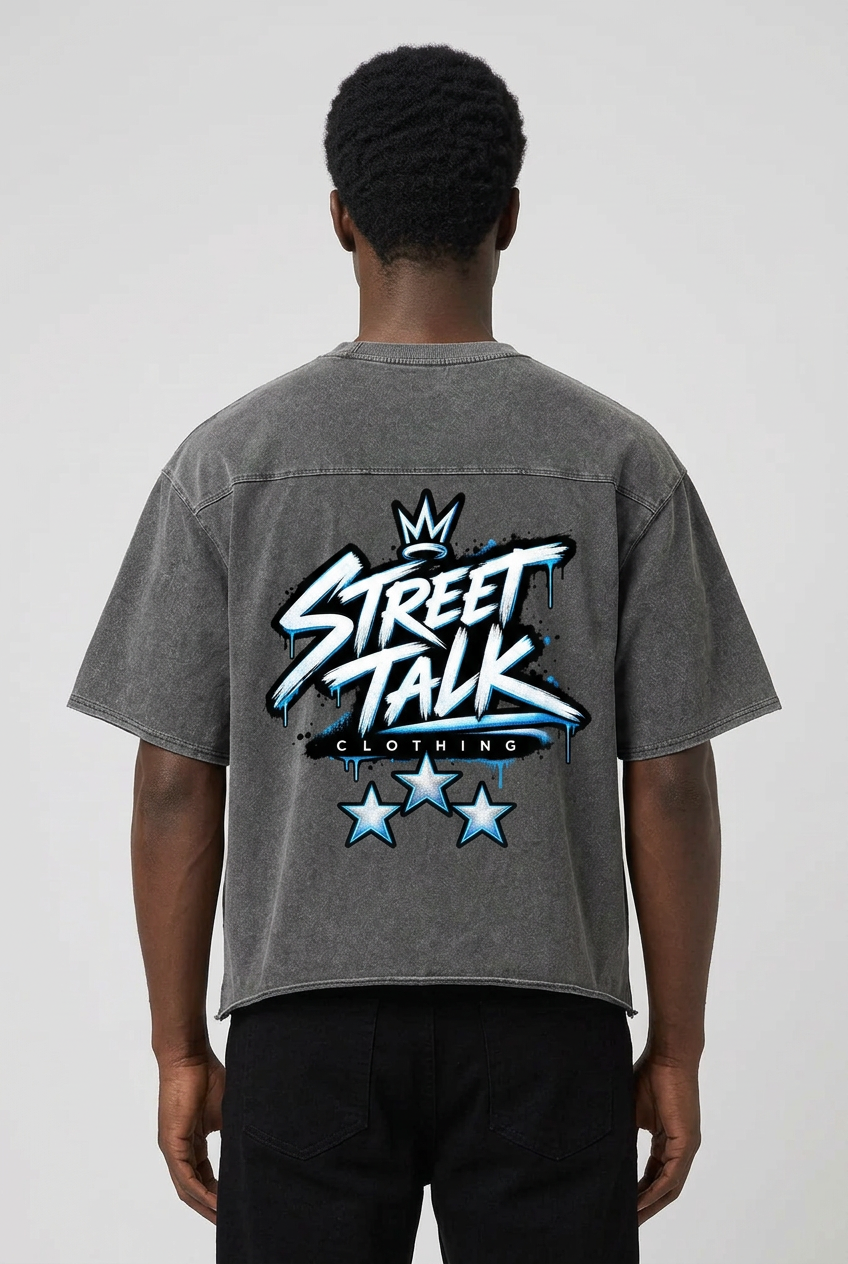 Rear view of male model wearing the Ground Level Tee in Ash Gray with crowned Street Talk Clothing artwork and three stars